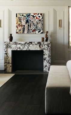 a living room filled with furniture and a painting on the wall above a fire place