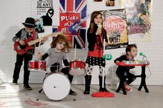 the children are playing music together in the room with flags and posters on the wall