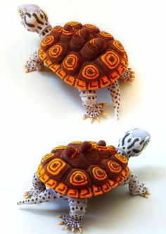 two stuffed tortoises sitting next to each other on top of a white surface