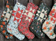 five christmas stockings lined up on a wooden surface