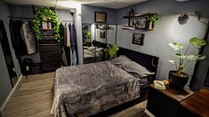 a bedroom with a bed, dresser and plants on the wall next to each other