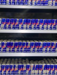 many cans of soda are stacked on shelves