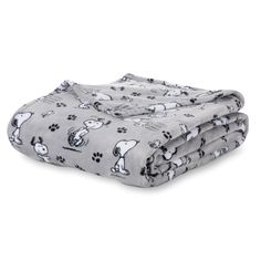 two blankets with dogs and paw prints on them, one is folded over the other