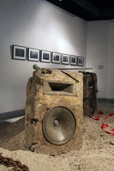 an old radio sitting on top of a pile of dirt in front of some pictures