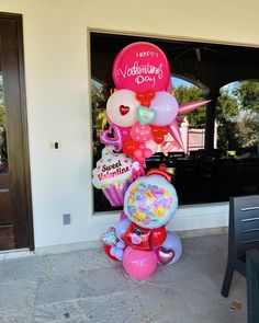 a bunch of balloons that are in front of a door with the words happy valentine's day on it