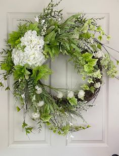 a wreath with white flowers and green leaves