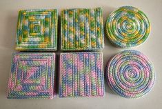 four coasters and two plates are made out of crocheted yarn on a table