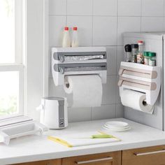 two rolls of toilet paper are hanging on the wall next to a kitchen counter top