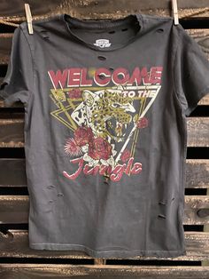 Country Deep Welcome To The Jungle 1980's  vintage unisex distressed T shirt in vintage wash black Throw back vintage tee from 1980's 40 Singles Jersey 100% Cotton Premium quality ringspun and compacted cotton Fine Cotton Jersey that is pigment dyed for a more vintage look Features tears and destroyed features at neck and on body Each piece is unique as this process is done by hand! 3.8 oz Made In USA Every garment dye item can be a slightly different shade in color since this is a laundry dye p Vintage Ripped Crew Neck Top, Acid Wash Ripped T-shirt With Crew Neck, Ripped Short Sleeve Graphic Tee, Retro Distressed Washed Black T-shirt, Ripped Graphic Tee With Short Sleeves, Vintage Washed Black Distressed T-shirt, Washed Black Distressed Grunge T-shirt, Black Throws, Welcome To The Jungle