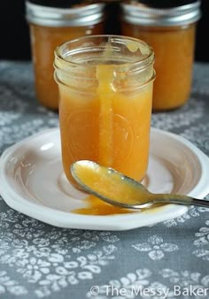 three jars filled with liquid sitting on top of a white plate