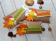 three thanksgiving cards with fall leaves and acorns on the table next to nuts