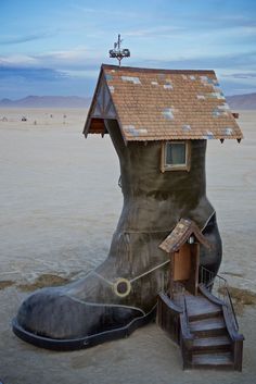 an unusual tree house in the desert with stairs leading up to it's roof