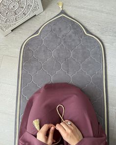 a woman is laying down with her hands on the back of a chair while sewing