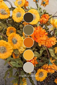 an arrangement of yellow and orange flowers with different shades