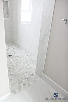 the bathroom is white and has marble tile on the shower wall, floor, and ceiling