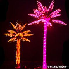 two palm trees are lit up in pink and yellow lights on a black background,