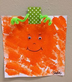 a child's handprinted picture of a carrot on a piece of paper