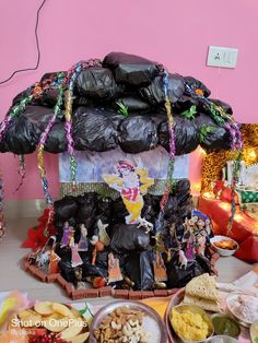 a table topped with lots of food next to a pink wall