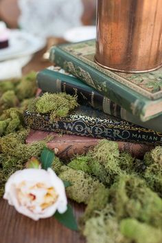 three books are stacked on top of each other with moss growing all over the edges