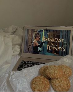 three cookies sitting on top of a bag next to a laptop