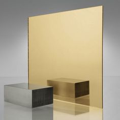 two metal boxes sitting next to each other on top of a reflective surface with one box in the middle