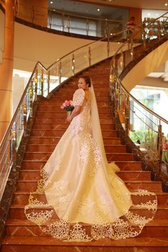 the bride is walking down the stairs in her wedding dress