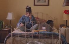 a woman sitting on top of a bed in a bedroom