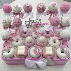 a pink and white box filled with lots of cupcakes on top of a table