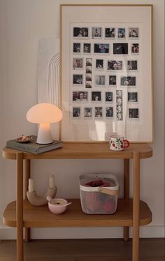 a wooden table topped with a lamp and pictures