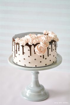 a white cake with chocolate icing and roses on top