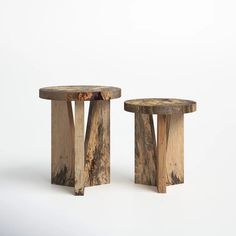 two wooden stools sitting next to each other on a white surface with no one around them