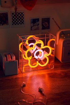 an illuminated object on a wooden table next to some wires and other things in front of it