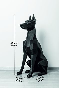 a black dog sitting on top of a wooden floor next to a wall with measurements