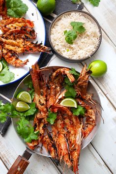 grilled shrimp with limes, rice and cilantro on a white table