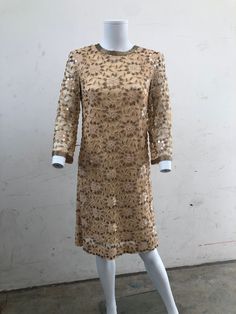 This rare 1950's original beaded dress is in very good condition. It has interesting floral bead design, 3/4 sleeve and zip detail at the back. Considering how old it is the beads are in very good condition and it looks barely worn. Gold Embellished Long Sleeve Sequin Dress, Vintage Long Sleeve Evening Mini Dress, Vintage Long Sleeve Mini Dress For Evening, Vintage Gold Dress For Festive Occasion, Gold Vintage Dress For Festive Occasions, Gold Sequin Formal Dress For Spring, Gold Embellished Mini Dress For Formal Events, Formal Gold Embellished Mini Dress, Gold Embellished Mini Dress For Formal Occasions