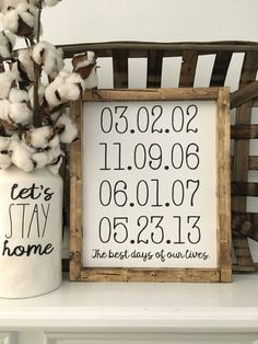 a wooden frame sitting on top of a shelf next to a vase filled with cotton