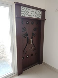 a wooden door with decorative designs on the front and side panels, in an empty room