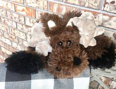 a stuffed animal with antlers on it's head sitting next to a brick wall