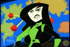 an animated character with long black hair and green clothes, sitting in front of a world map