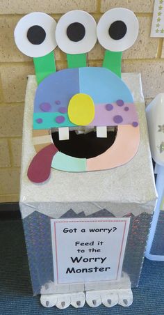 a cardboard box with paper cut out of it that says, got a worry? feed it worry monster