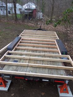 a flatbed trailer is being built in the woods