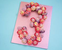 a number made out of cupcakes sitting on top of a pink paper