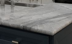 a marble counter top in a kitchen next to a sink