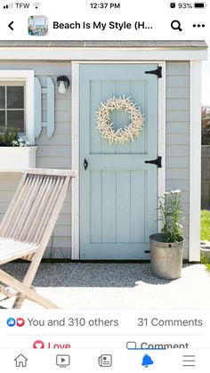 a blue shed with a wreath on the door and a lawn chair in front of it