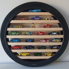 a wall mounted toy car display in a black circle with wooden shelves on each side