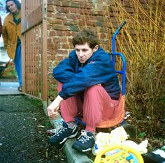 a man sitting on top of a green bench next to a child's toy