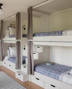 bunk beds are lined up against the wall in this room with white walls and wood flooring