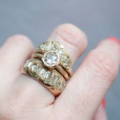 a close up of a person's hand holding two rings