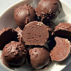 a white bowl filled with chocolate truffles on top of a table