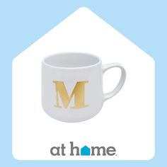 a white coffee mug with the letter m on it's front and bottom half